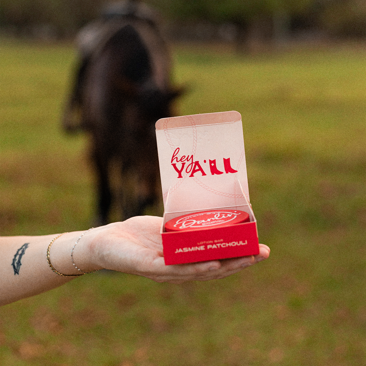 A Darlin’ lotion bar and its packaging held outdoors.